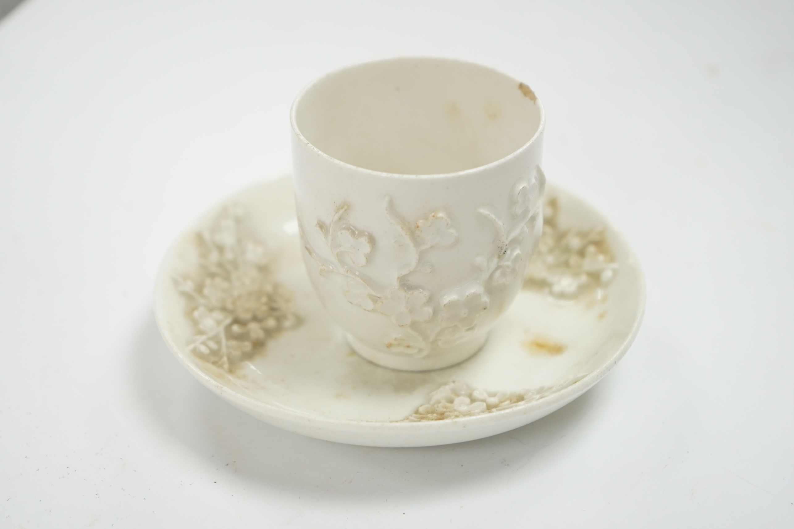 A Bow prunus sprigged coffee cup and saucer, c.1760, saucer 11.5cm diameter, cup 6cm high. Condition - cup has a chip to the rim and both saucer and cup interior have wear to glazing